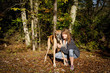 Woman and her great Dane in clearing in forest in autumn